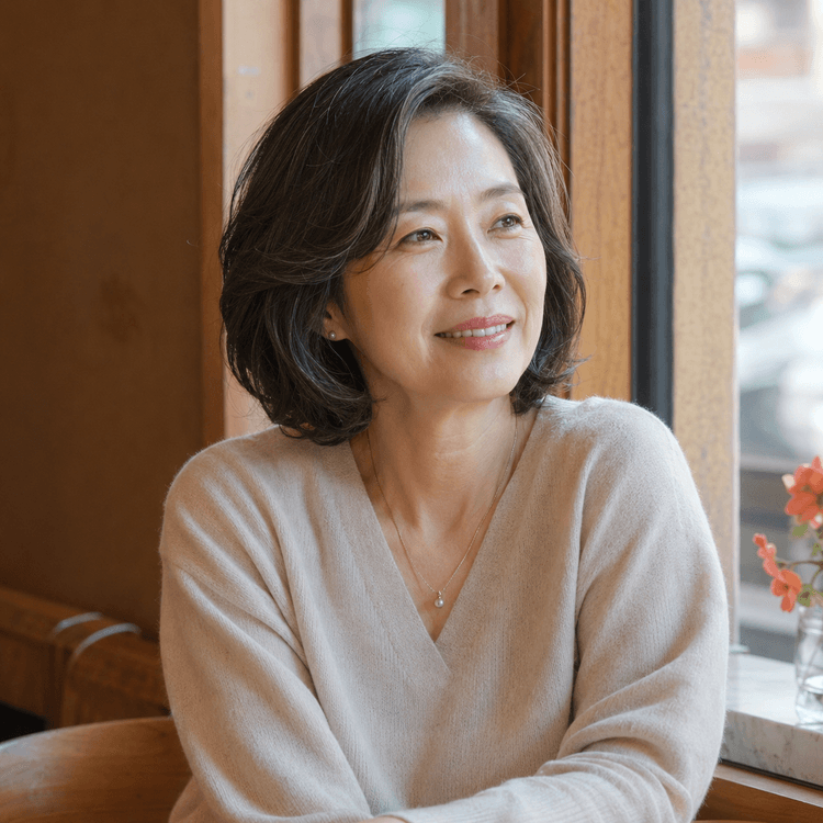 창가에 앉은 평온한 50대 여성